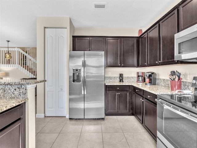 kitchen featuring pendant lighting, dark brown cabinetry, stainless steel appliances, and light stone counters