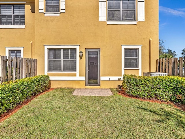 view of exterior entry with a yard