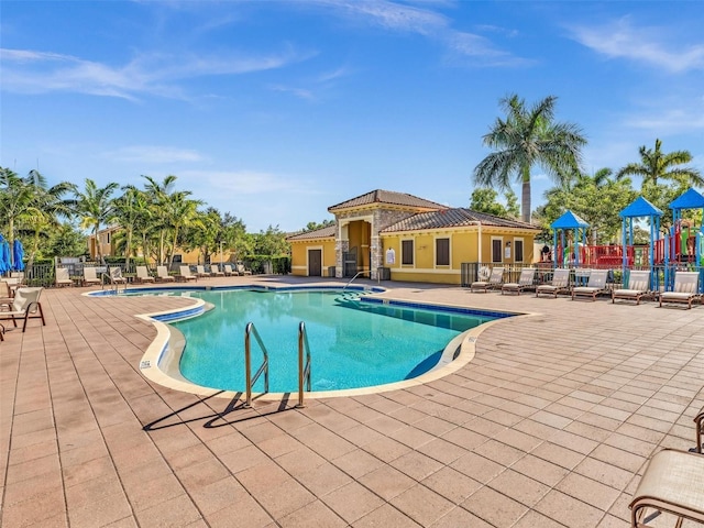 view of pool with a patio and a playground