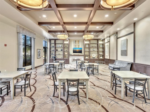 dining space featuring beamed ceiling, a fireplace, and coffered ceiling