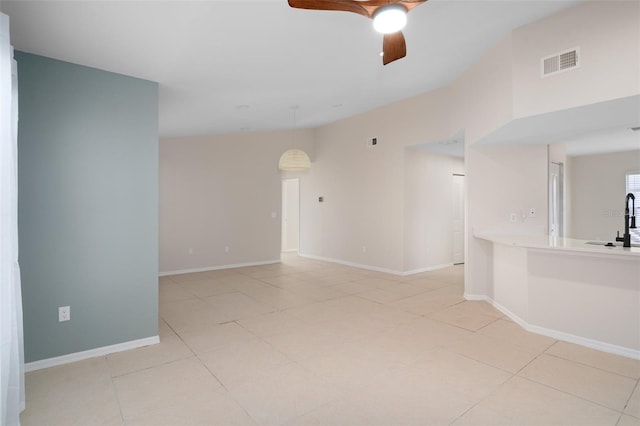 empty room with ceiling fan, sink, and light tile patterned flooring