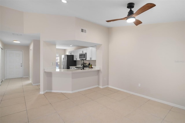 kitchen with white cabinets, ceiling fan, light tile patterned floors, kitchen peninsula, and stainless steel appliances