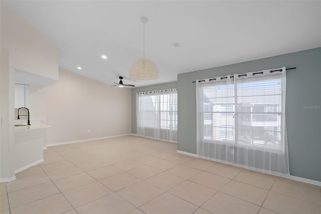 tiled empty room featuring ceiling fan and sink