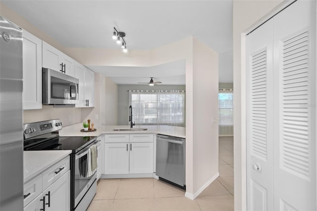 kitchen featuring white cabinets, stainless steel appliances, a healthy amount of sunlight, and sink