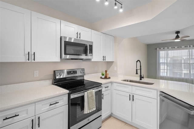 kitchen with white cabinetry, sink, ceiling fan, stainless steel appliances, and light tile patterned flooring