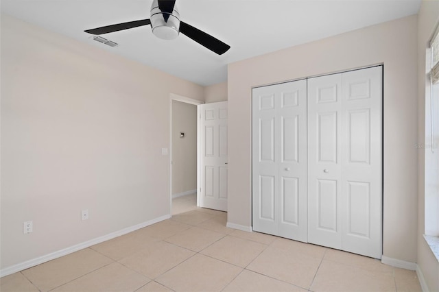 unfurnished bedroom featuring ceiling fan, a closet, and light tile patterned flooring