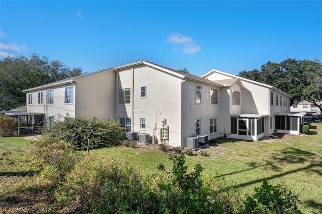 back of property with a yard, central AC unit, and a sunroom