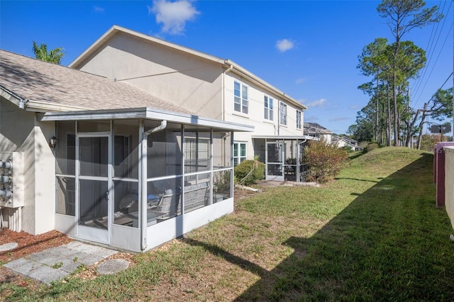 rear view of house featuring a sunroom and a yard