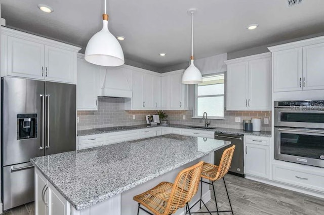 kitchen featuring sink, stainless steel appliances, white cabinetry, and custom exhaust hood