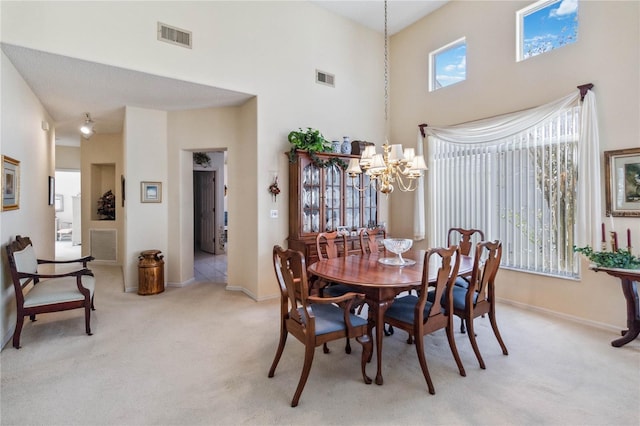 carpeted dining room with a high ceiling and a chandelier