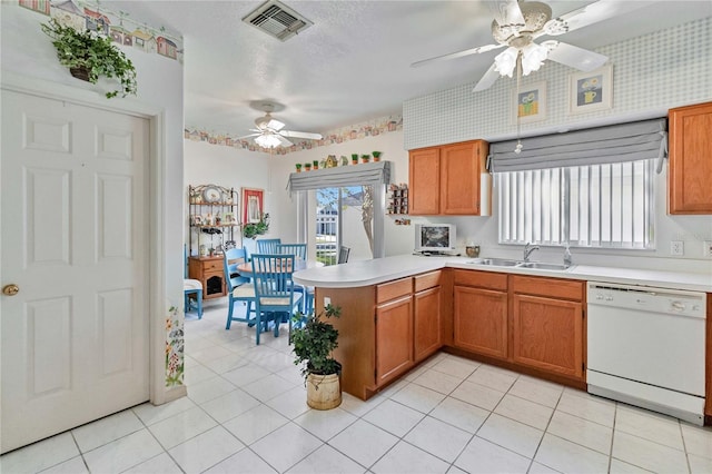 kitchen featuring ceiling fan, dishwasher, sink, kitchen peninsula, and light tile patterned flooring