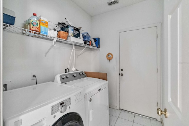 laundry room featuring separate washer and dryer and light tile patterned floors