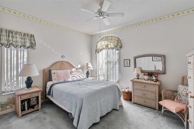 bedroom with carpet, ceiling fan with notable chandelier, and a textured ceiling