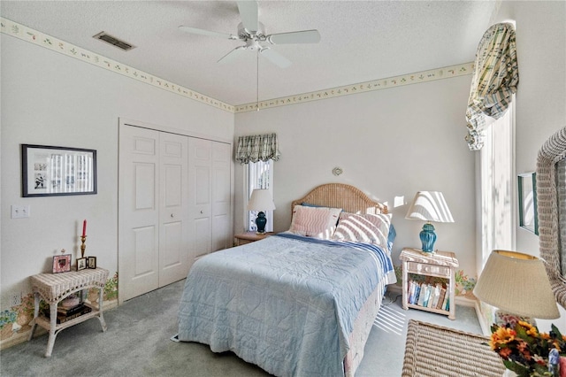 bedroom with carpet flooring, ceiling fan, a textured ceiling, and a closet