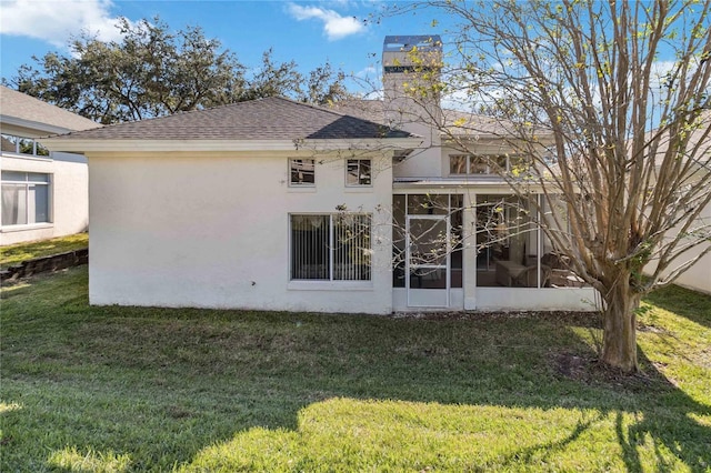 back of property with a sunroom and a yard