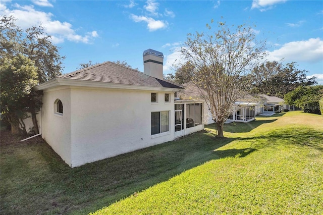 back of house featuring a yard and a sunroom