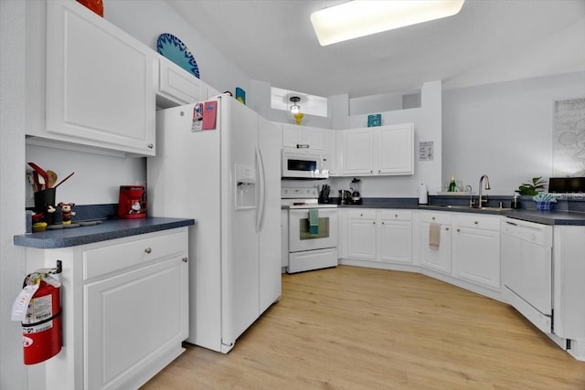 kitchen with sink, white cabinets, white appliances, and light wood-type flooring