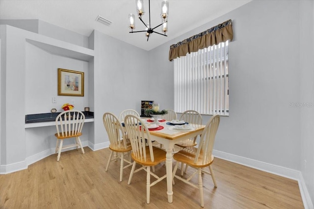 dining area featuring a chandelier and light wood-type flooring