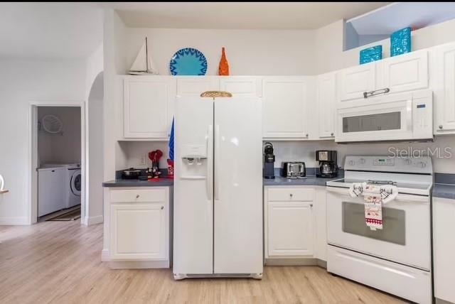 kitchen with white cabinets, light wood-type flooring, and white appliances