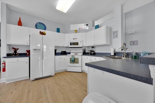 kitchen featuring white cabinetry, sink, white appliances, and light wood-type flooring