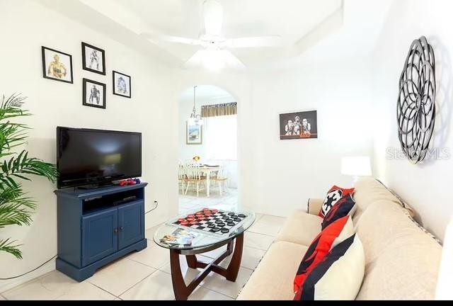 living room with ceiling fan and light tile patterned flooring