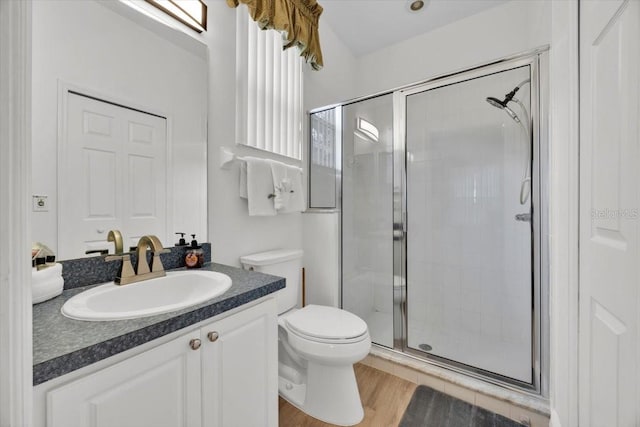 bathroom featuring vanity, hardwood / wood-style flooring, toilet, and an enclosed shower