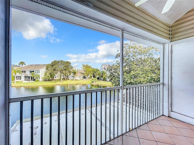 unfurnished sunroom with ceiling fan, a water view, and lofted ceiling