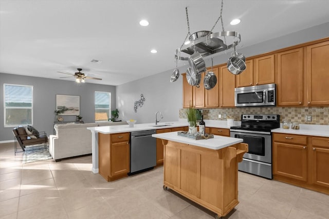 kitchen with plenty of natural light, a kitchen island, sink, and stainless steel appliances