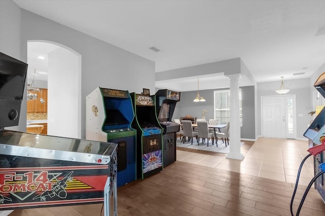 game room with wood-type flooring and decorative columns