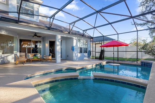 view of pool with an in ground hot tub, a patio, glass enclosure, and ceiling fan