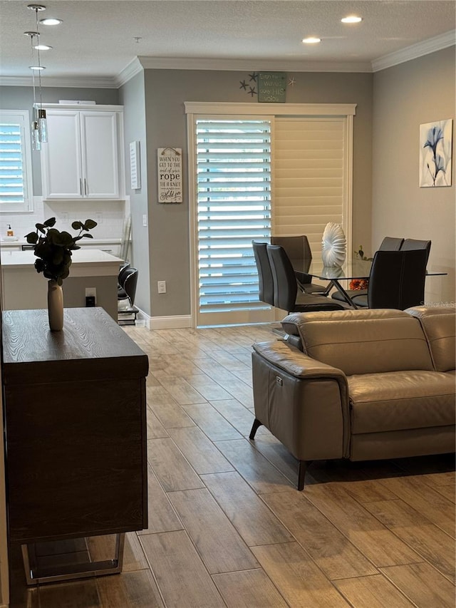 living room featuring crown molding, a wealth of natural light, and light hardwood / wood-style flooring