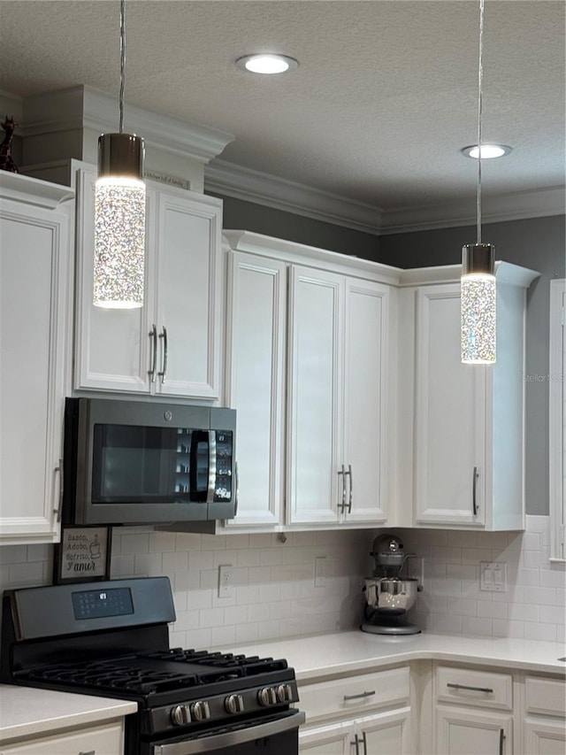 kitchen with white cabinetry, stainless steel appliances, and hanging light fixtures