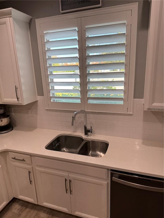 kitchen featuring dishwasher, dark hardwood / wood-style flooring, white cabinetry, and sink