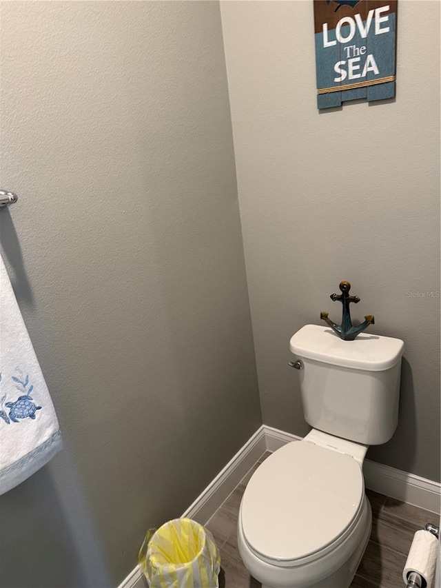 bathroom with toilet and wood-type flooring