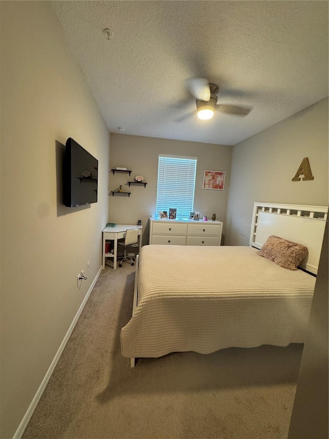 carpeted bedroom featuring a textured ceiling and ceiling fan