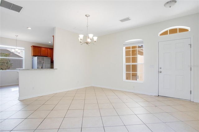 interior space with light tile patterned flooring and a notable chandelier