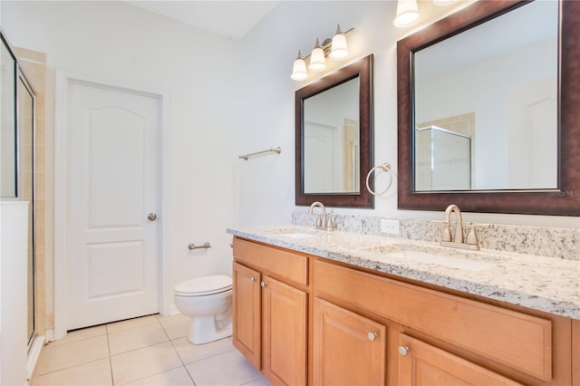 bathroom featuring tile patterned floors, vanity, a shower with shower door, and toilet