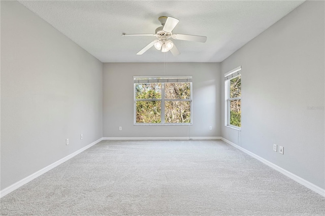 carpeted empty room featuring a textured ceiling and ceiling fan