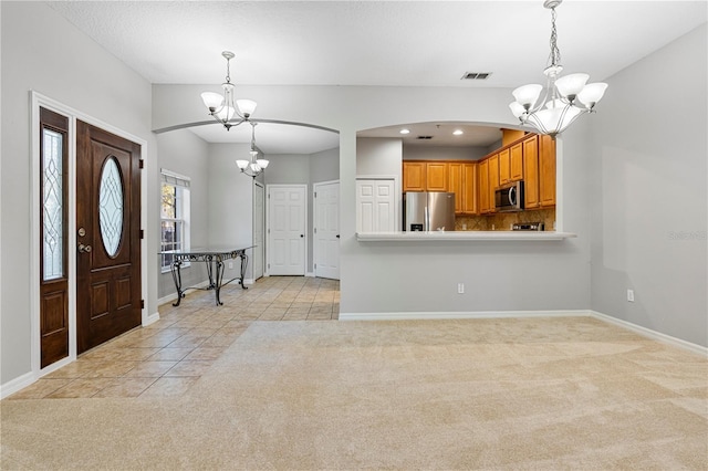 kitchen featuring decorative light fixtures, light carpet, and appliances with stainless steel finishes