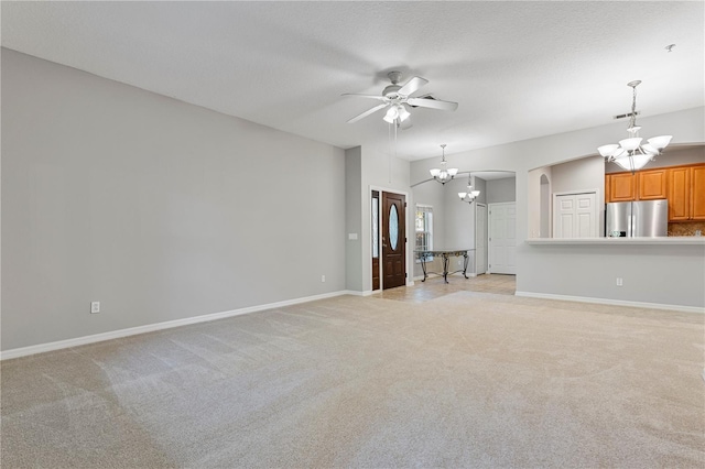 unfurnished living room with light carpet and ceiling fan with notable chandelier