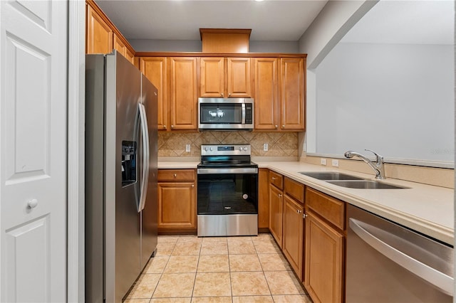 kitchen with decorative backsplash, sink, light tile patterned floors, and stainless steel appliances