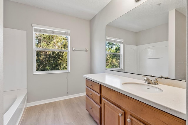 bathroom featuring plenty of natural light, vanity, a textured ceiling, and hardwood / wood-style flooring