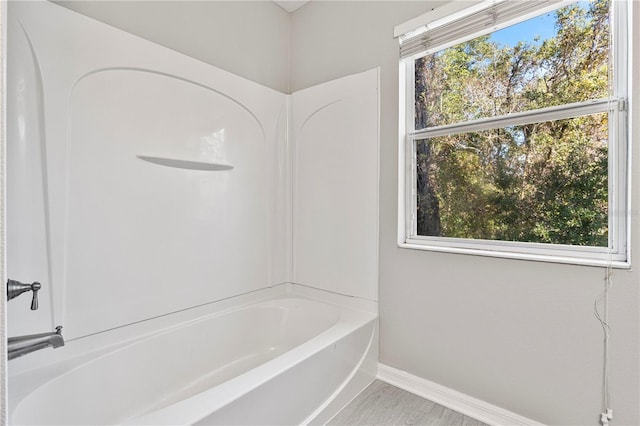 bathroom with a washtub, hardwood / wood-style floors, and a wealth of natural light