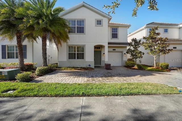 mediterranean / spanish-style house with a garage and central air condition unit