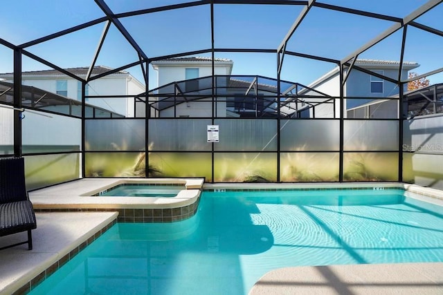 view of swimming pool featuring a lanai and an in ground hot tub