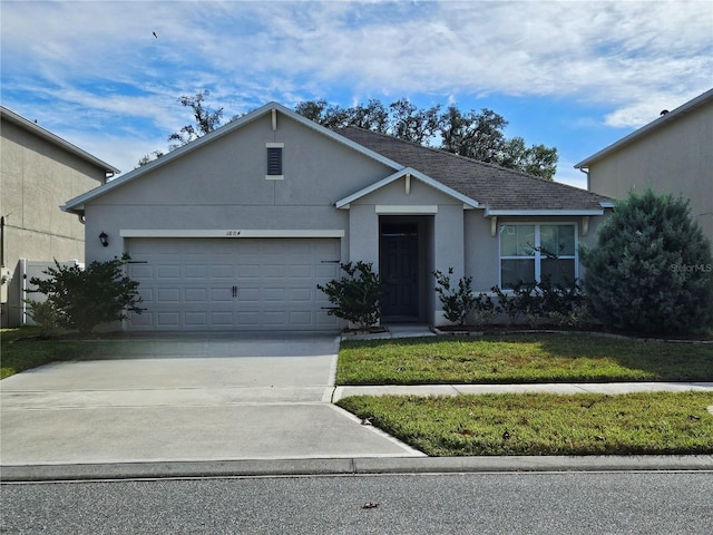 ranch-style home featuring a front lawn and a garage