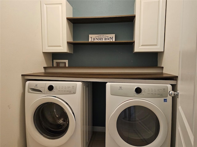 laundry area with cabinets, tile patterned flooring, and washer and clothes dryer