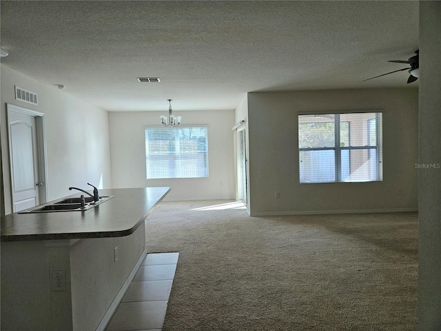 interior space with a wealth of natural light, light colored carpet, sink, and hanging light fixtures