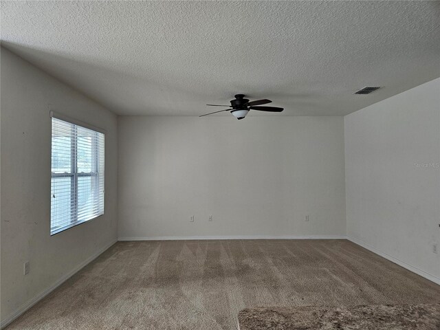 carpeted empty room featuring a textured ceiling and ceiling fan