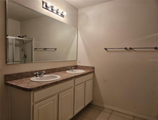 bathroom with tile patterned flooring, vanity, and a shower with shower door